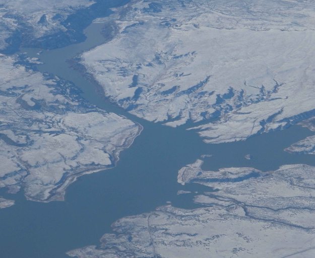 {Image:  photo taken from a plane of a river with snow-covered banks.}