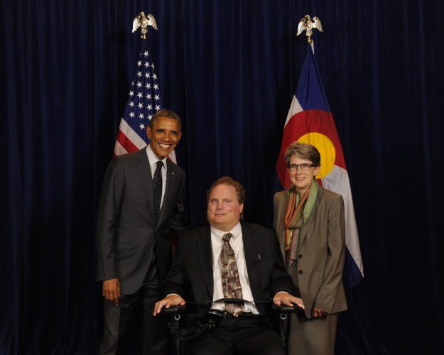 Image:  President Obama next to Tim Fox (white man in suit and tie sitting in wheelchair) and Amy Robertson (white woman in suit and scarf).