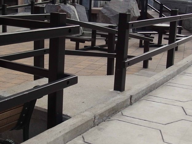 Photo showing ramp down to lowered area of pedestrian mall; there is a single step up to the ramp, however. 