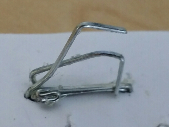 Image:  close up photo of 3 or 4 badly mangled staples all attempting to occupy the same staple-space in the corner of a document. 