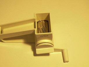 Image:  small cylindrical grating blade in a plastic housing with a turn handle.  