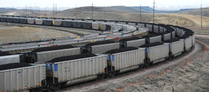 {Image: four parallel coal trains rounding a bend in the track, the front two with coal cars full of coal.}