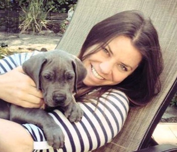 {Image: brown-haired light-skinned woman holding adorable gray puppy, both in lawn chair.}