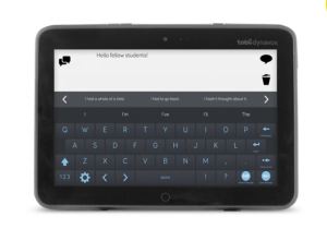 Image: Dynavox speech generating device; similar appearance to a tablet; bottom half containing a QWERTY keyboard; top half a field showing the text being typed.