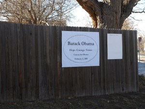 Wooden fence with poster reading "Barack Obama. Hope. Courage. Vision. Caucus for Obama. February 5, 2008"