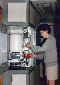 Amy in shorts and sweater getting coffee from the samovar.